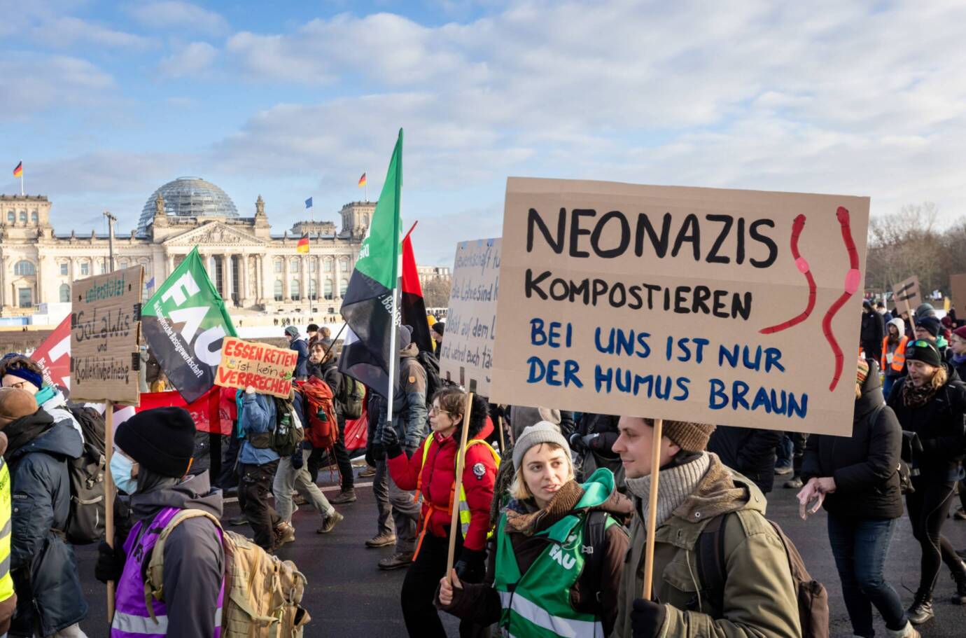 Protestierende vor dem Reichstagsgebäude mit Schildern.