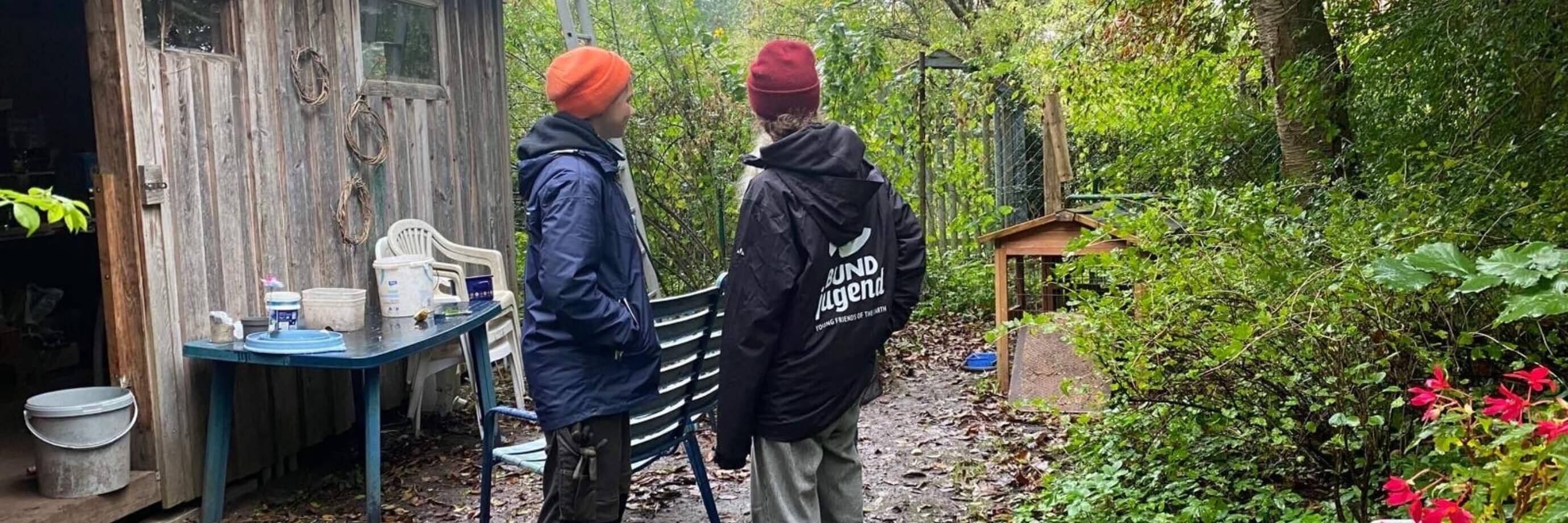 Zwei Personen vor einer Hütte im Garten