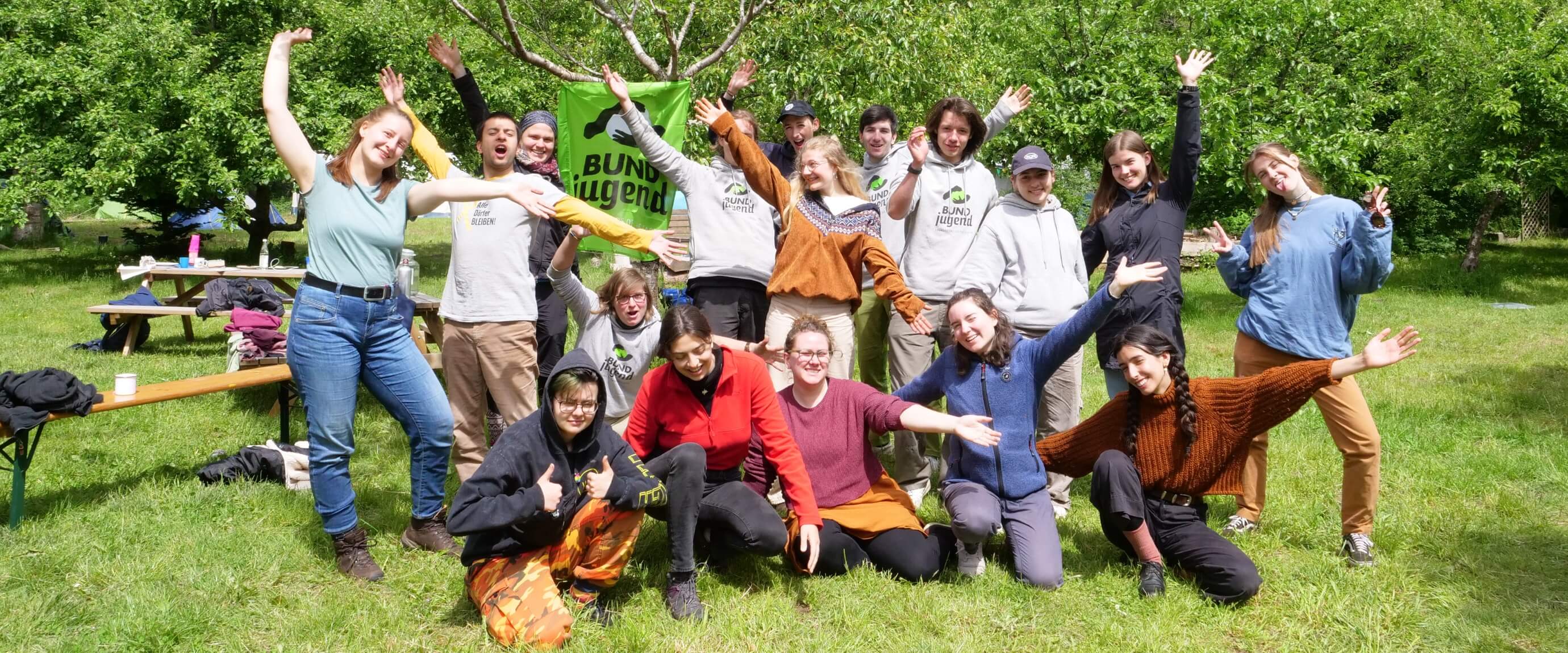 Gruppe junger Menschen jubelt im Freien.