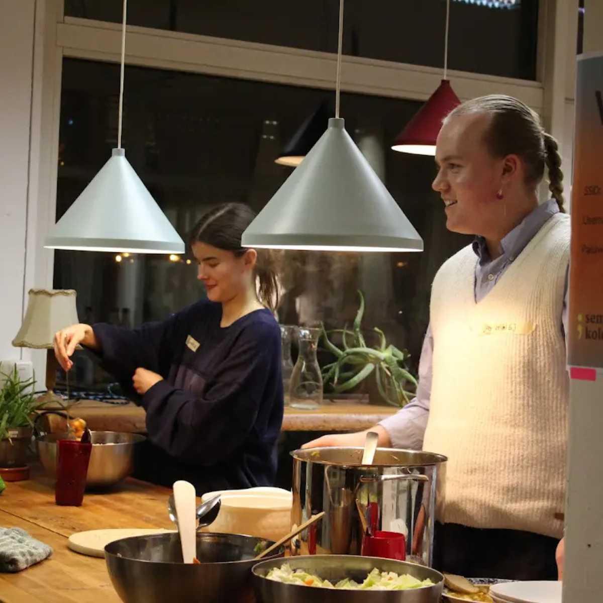 Menschen kochen gemeinsam in gemütlicher Küche.