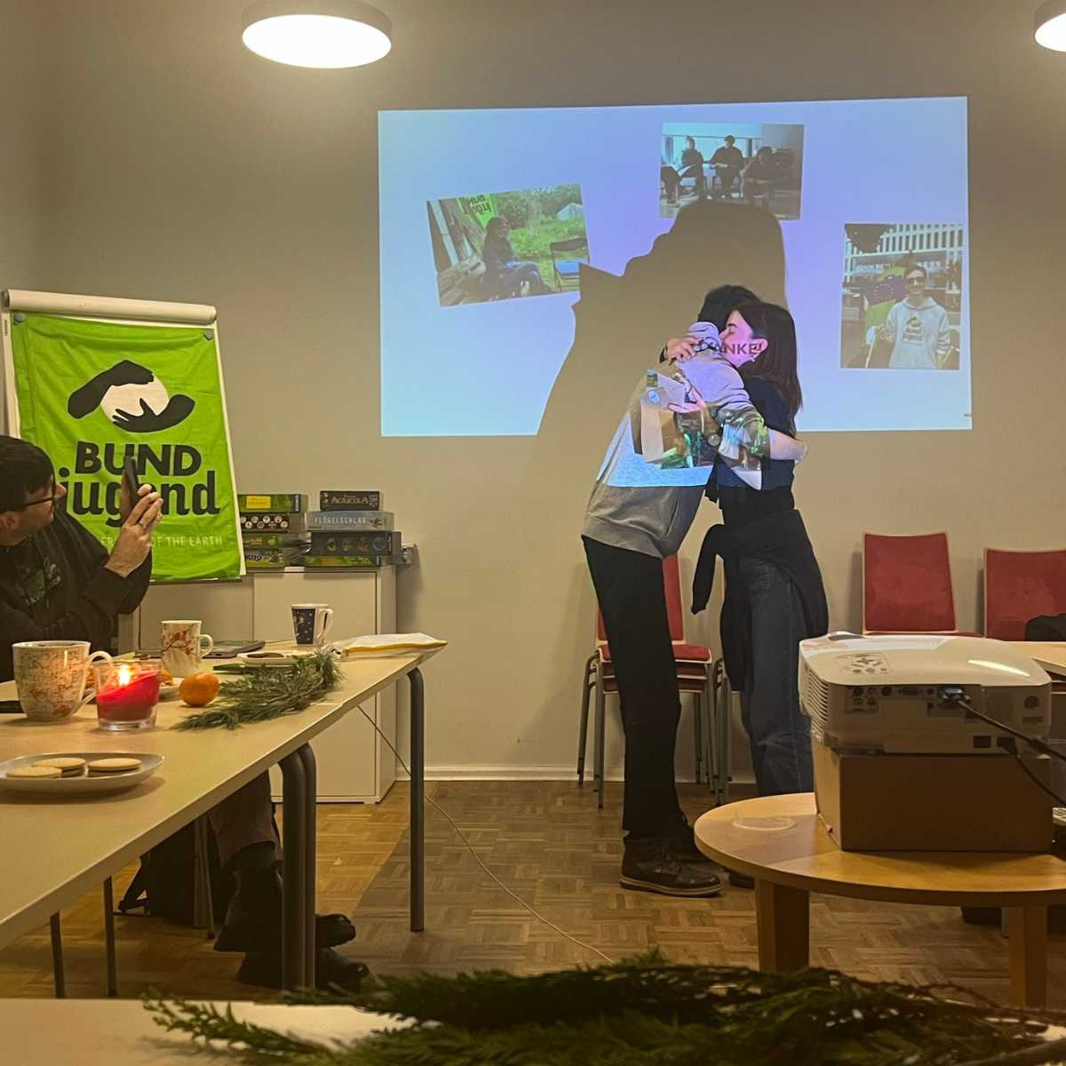 Umarmung bei Präsentation, Banner im Hintergrund