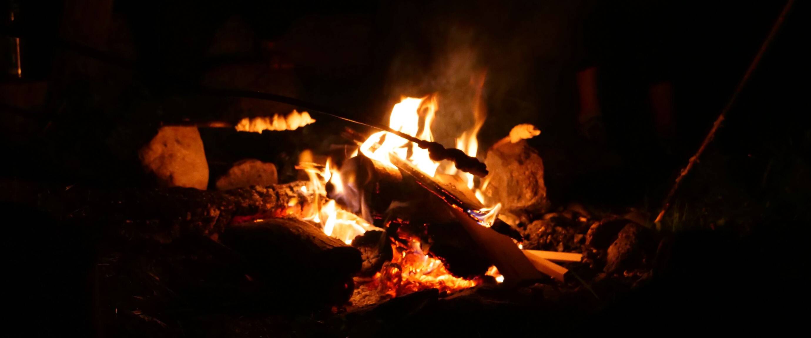 Stockbrot am Lagerfeuer in der Nacht