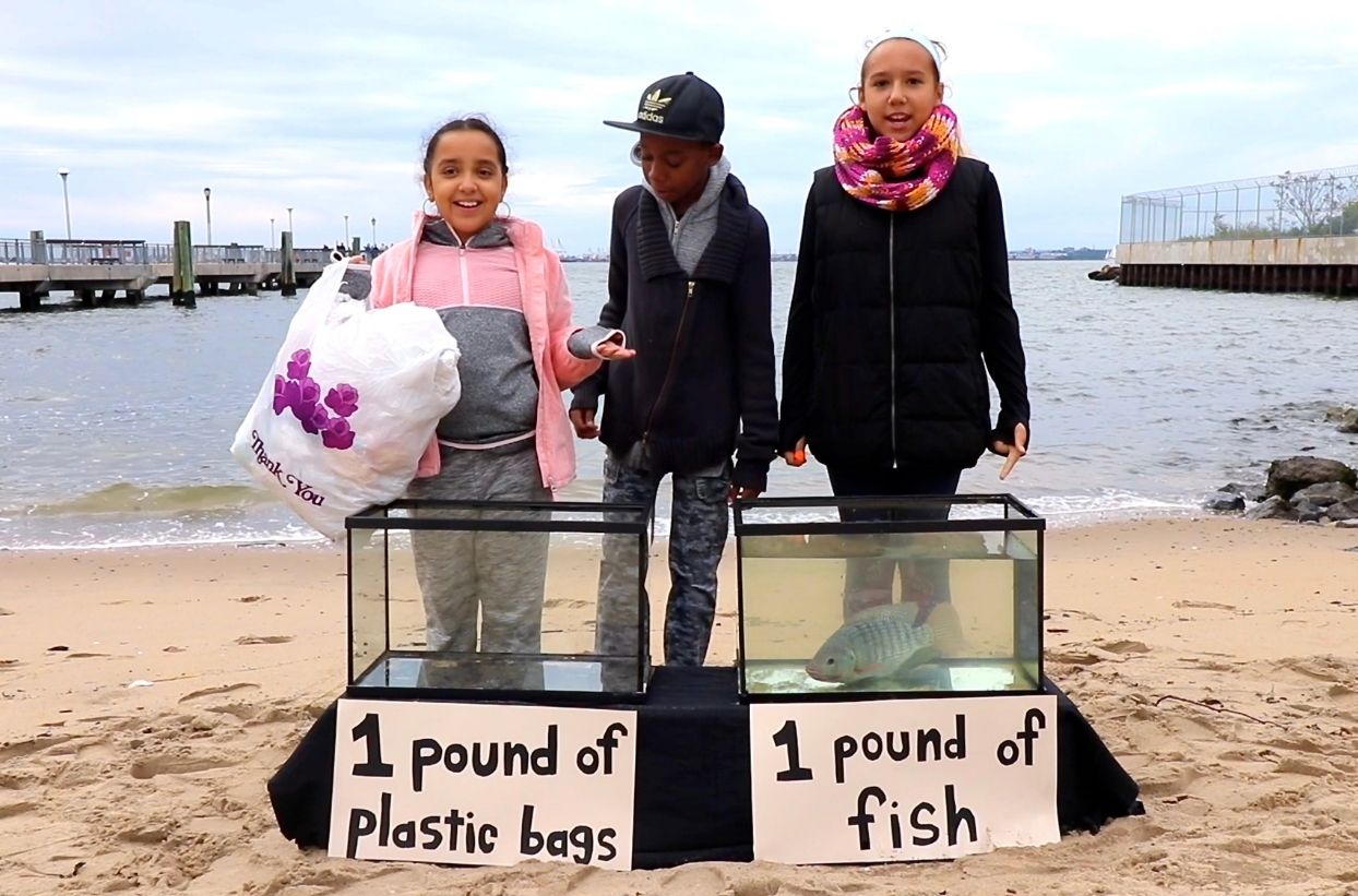 Kinder am Strand mit Plastik und Fischtank