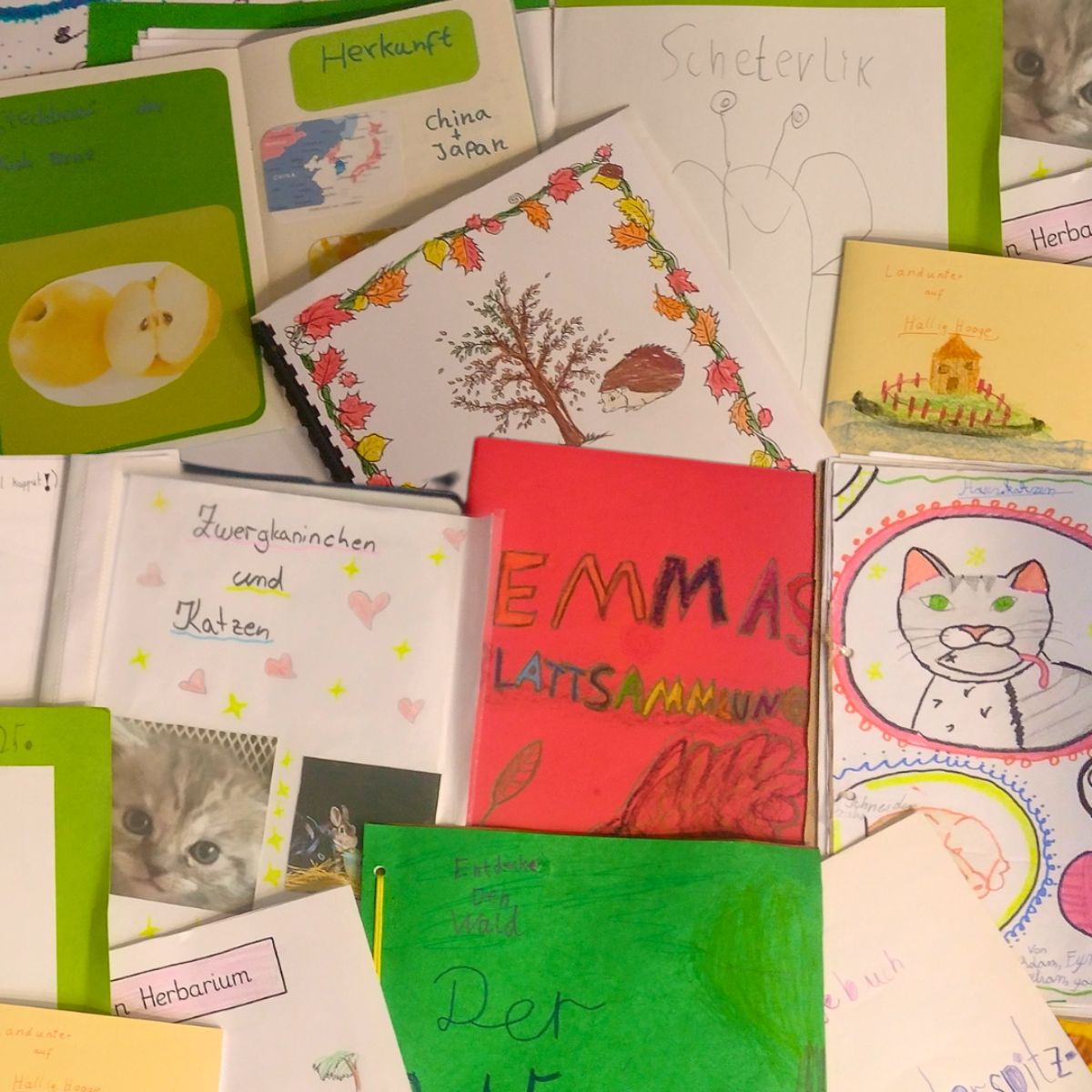 Bunte Kinderzeichnungen und Mappen auf einem Tisch